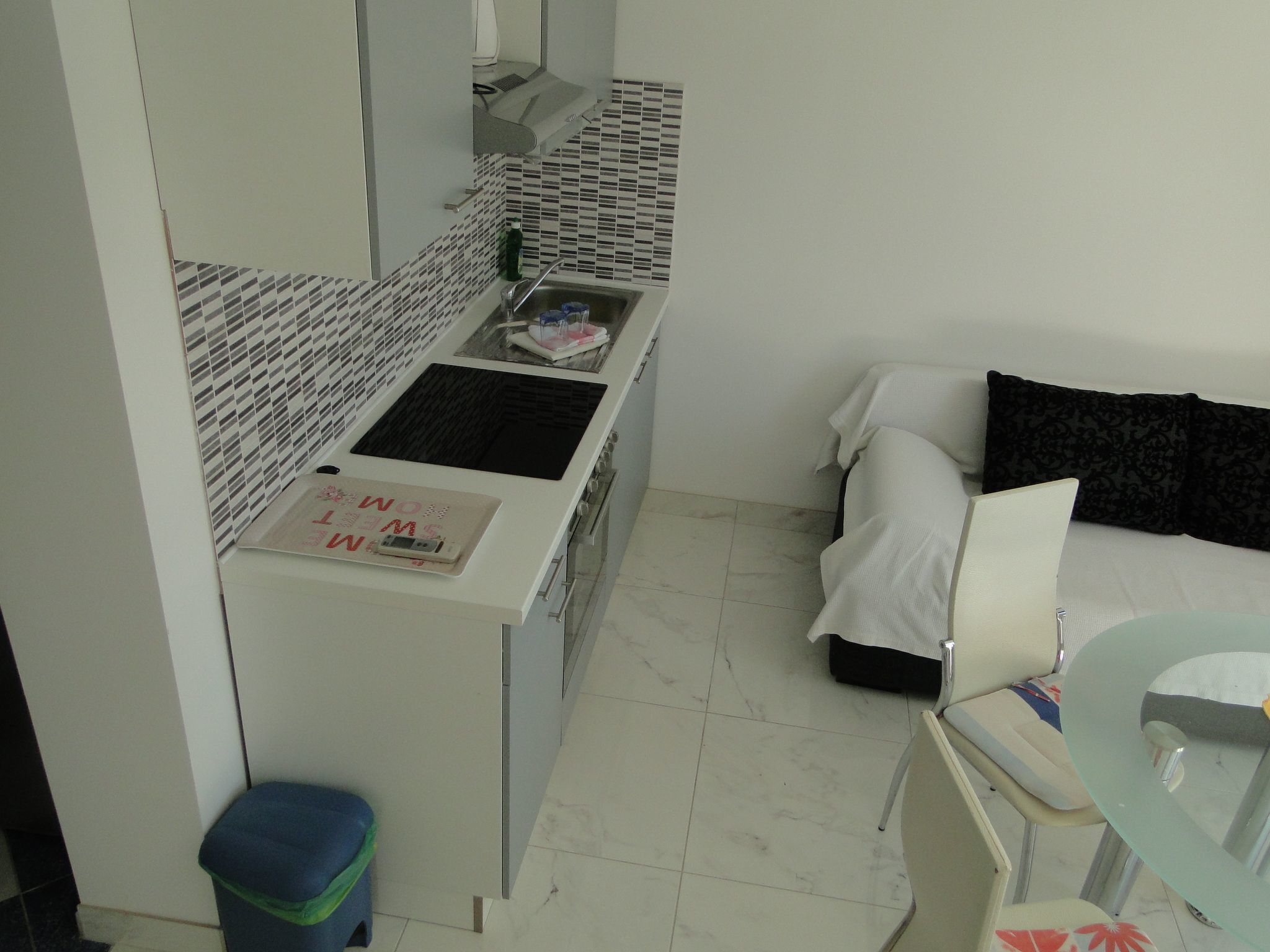 A compact kitchen with a sink, stove, and a small dining area with a table and chairs.
