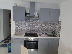 A compact kitchen with a built-in oven, a coffee maker, and a sink. - "Mir" mit Blick auf das Wasser by Interhome (Primošten)