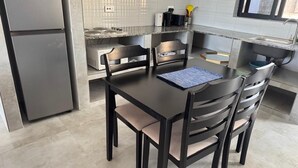 A kitchen with a dining table, chairs, a refrigerator, and a microwave. - Apartment in siavonga (Siavonga)