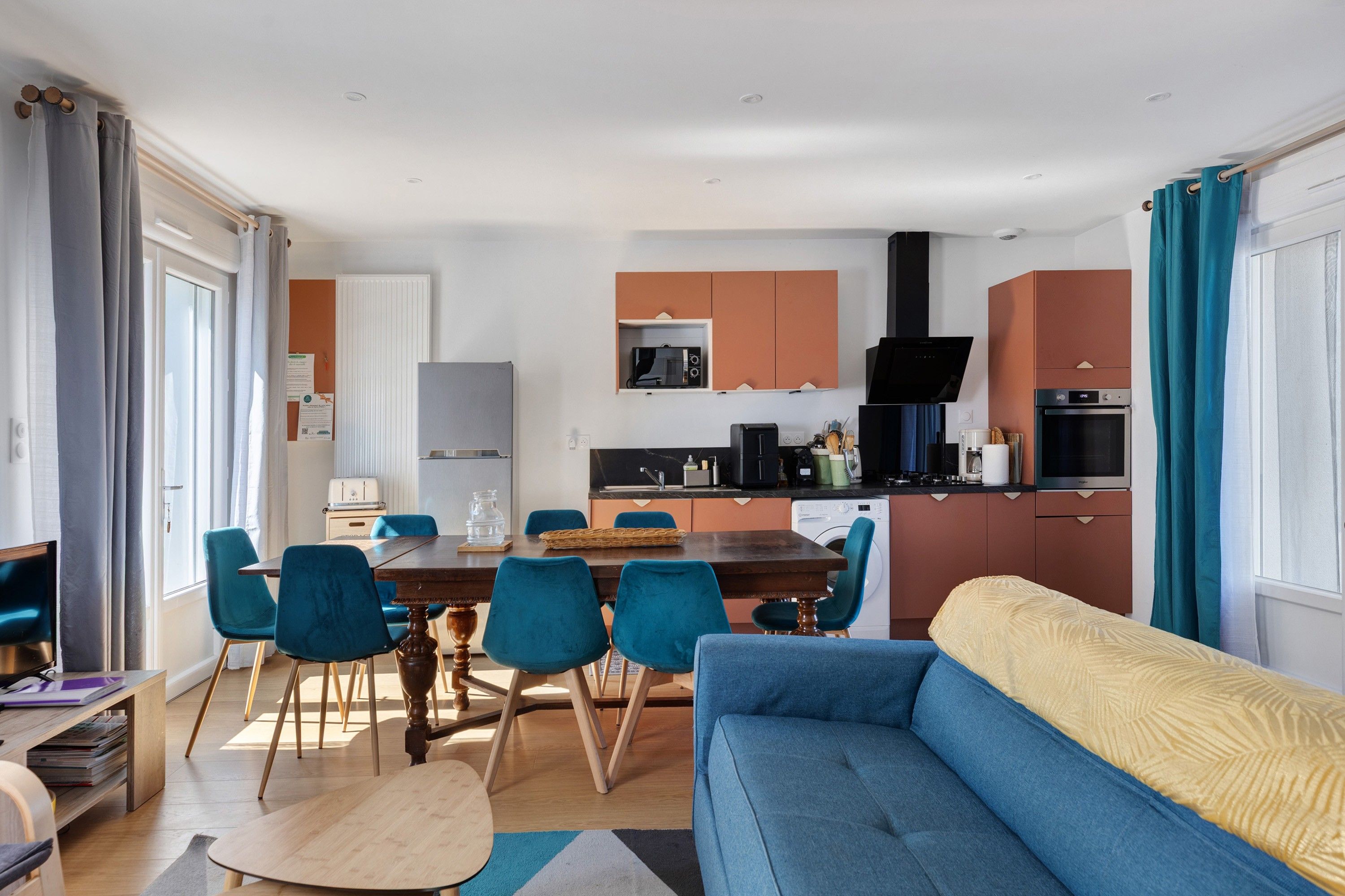 A modern apartment with a dining area, kitchen, and living room.