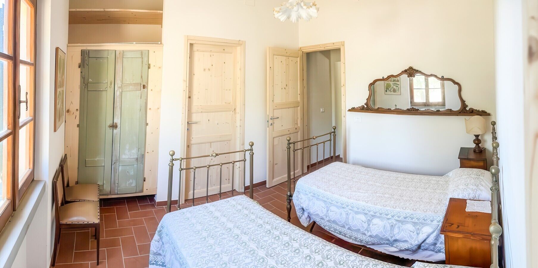 Un dormitorio con dos camas, un banco y una ventana.