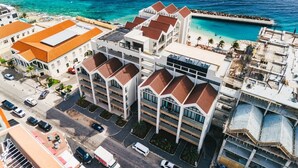 Hotel de vários andares com um pátio central, próximo a uma praia e a uma piscina.