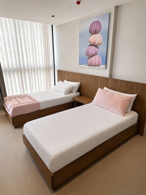 A hotel room with two beds, a wooden headboard, a painting on the wall, and a window with blinds. - Majestic 406 2-Bed Ocean View Suite by Bocobay (Willemstad)