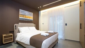 Ett modernt hotellrum med en stor säng, ett sängbord och en garderob.