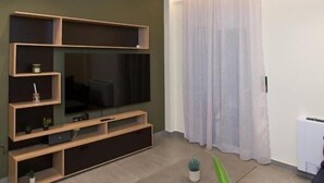 Ett modernt vardagsrum med en platt-TV, inbyggda hyllor och en minimalistisk design.