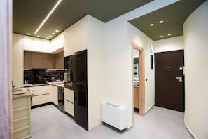 Une cuisine moderne dotée d’appareils électroménagers intégrés, d’un radiateur blanc et d’une porte en bois.