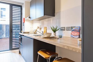 Eine moderne Küche mit Backofen, Spüle und Essbereich mit Hockern.