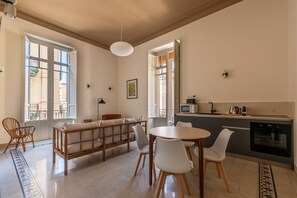 Eine moderne Küche mit Essbereich, großen Fenstern und Blick ins Freie.