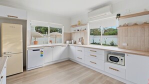 Una cocina moderna con armarios blancos, lavavajillas integrado y microondas.