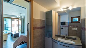 Un baño moderno con un espejo grande, un lavabo y una zona de ducha.