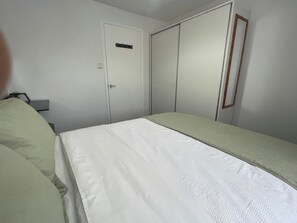A bedroom with a bed, a wardrobe, and a mirror. - One Bedroom Apartment Sleeps 2 With Free Parking (London)
