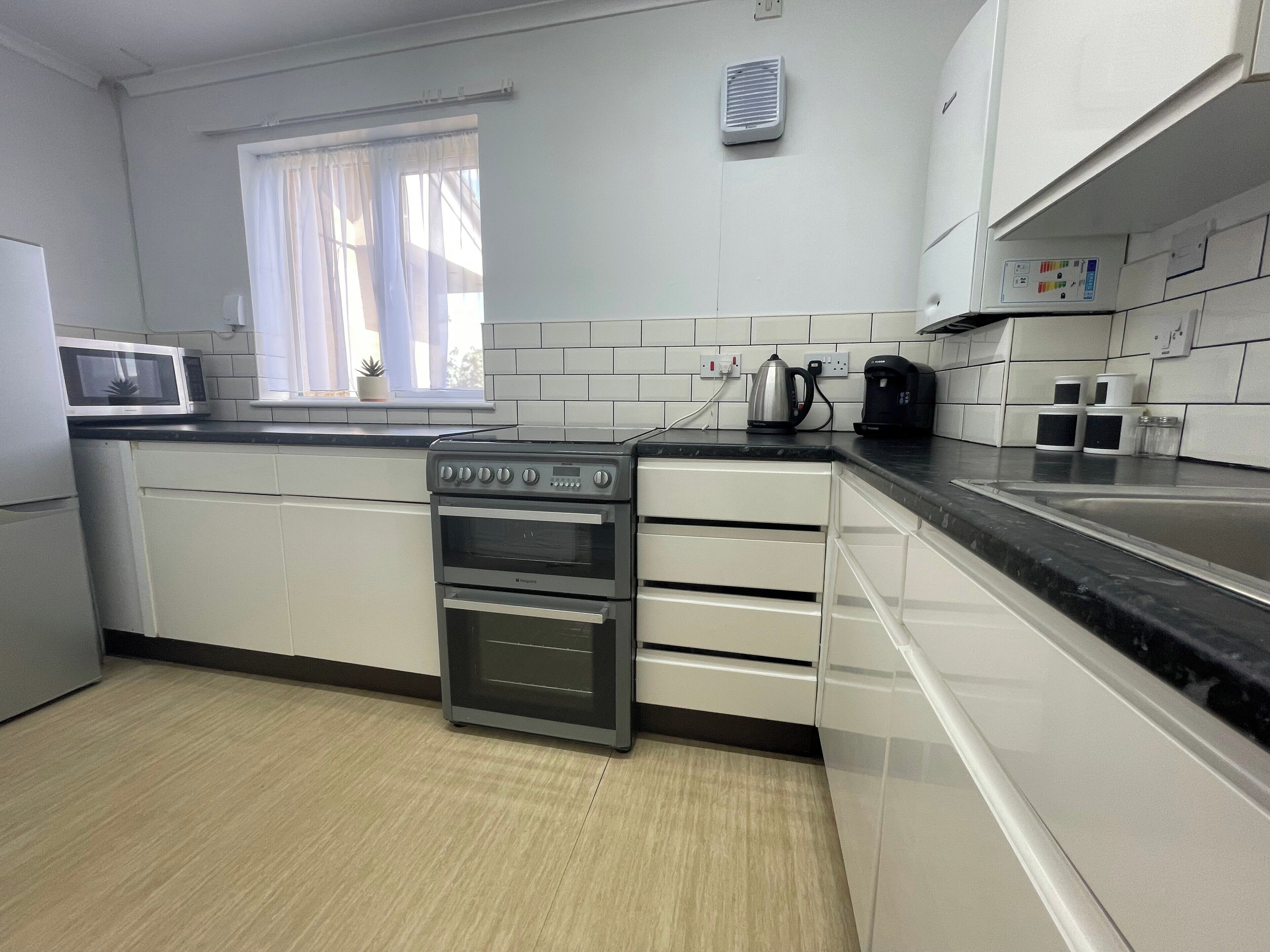 A modern kitchen with a built-in oven, a microwave, and a coffee maker.