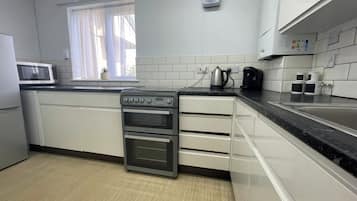 A modern kitchen with a built-in oven, a microwave, and a coffee maker.