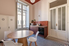 A compact kitchen with a dining area, a built-in oven, and a view through the window. - Roma 1923 - Casa Rossa by Wonderful Italy (Palermo)