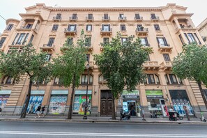 A multi-story building with a classical architectural style, featuring a central entrance with a door and windows on each floor. - Roma 1923 - Casa Blu by Wonderful Italy (Palermo)