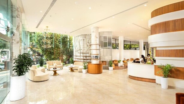 A modern lobby with a reception desk, seating area, and large windows. - Hotel Explora Calicut by Nova (Kozhikode)