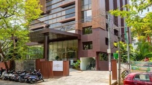 A modern building with a prominent vertical design, large windows, and a covered entrance area. - Hotel Explora Calicut by Nova (Kozhikode)