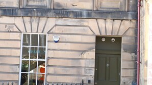 A two-story building with a green door and two windows. - Meus Apartments (Edinburgh)