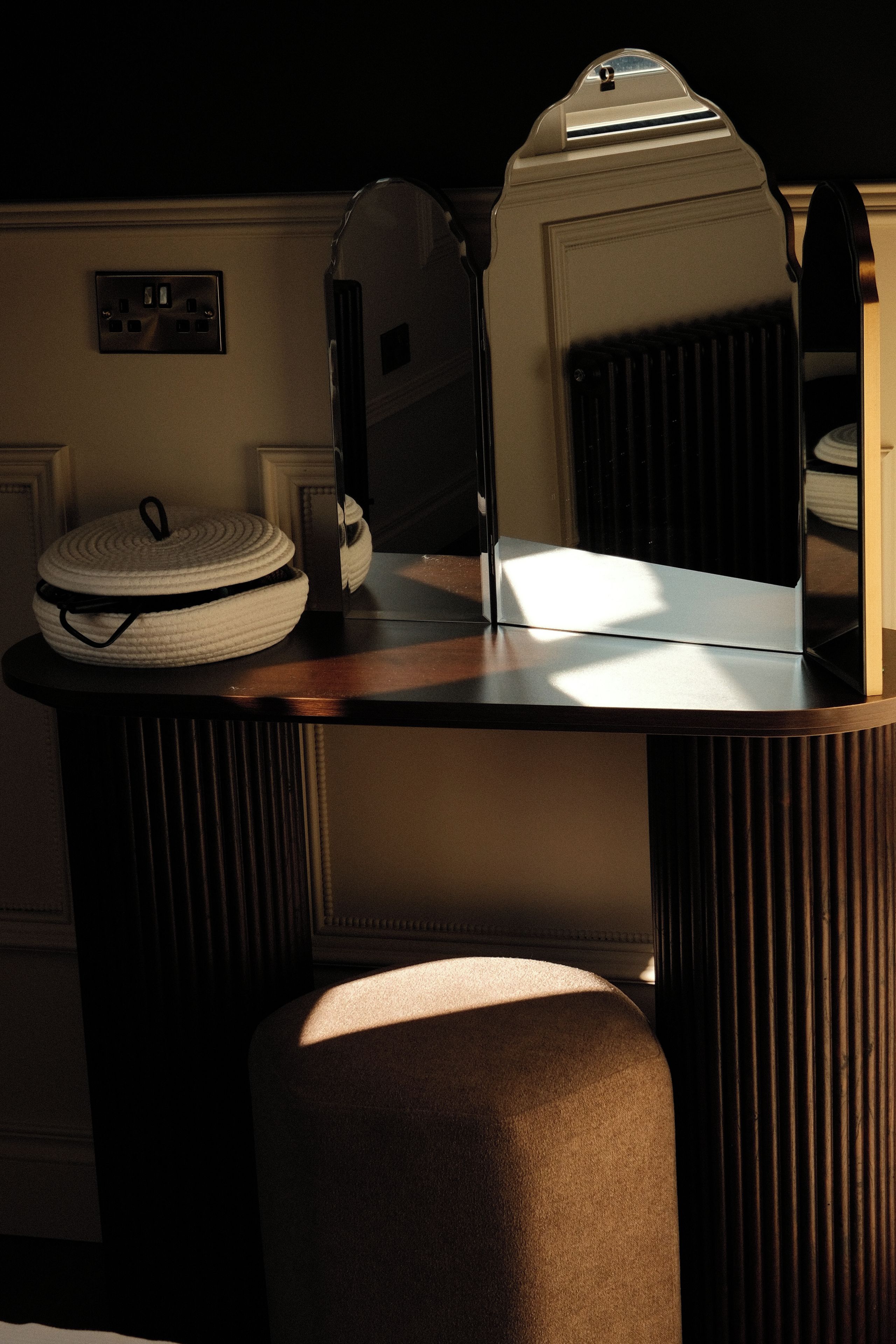 Une pièce avec une table ronde, un miroir et un radiateur.