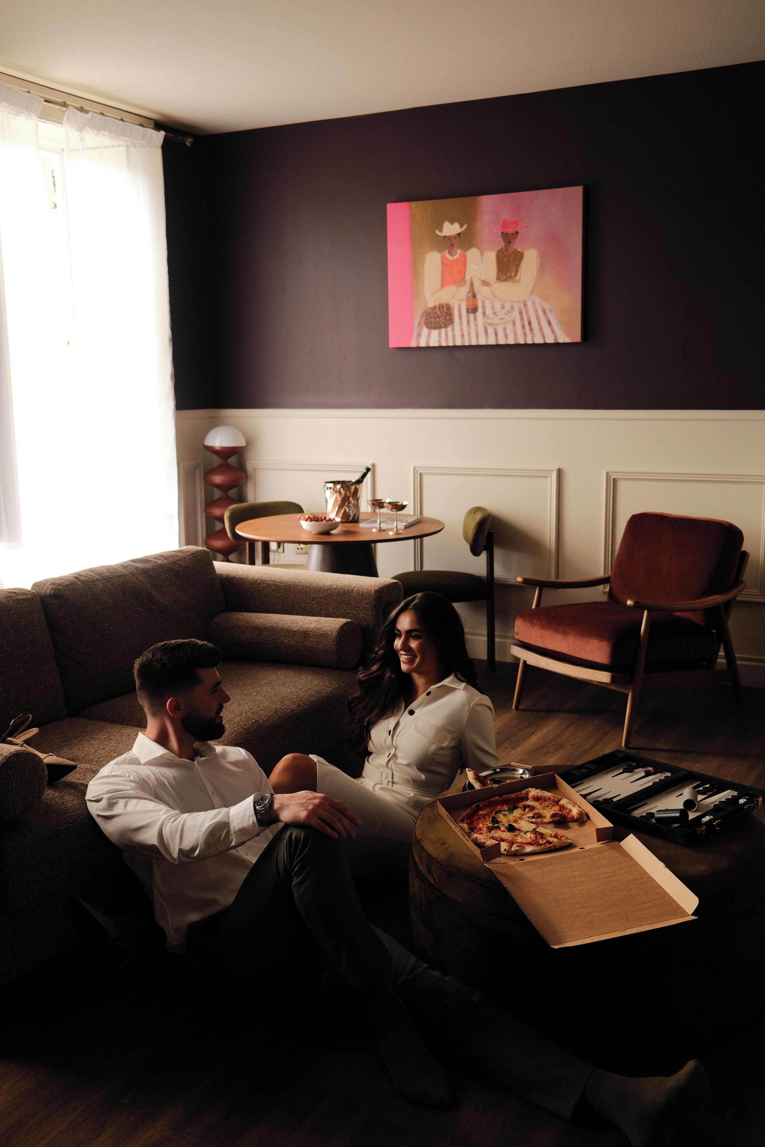 A living room with a sofa, a coffee table, and a pizza box.
