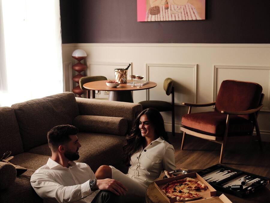 A living room with a sofa, a coffee table, and a pizza box.