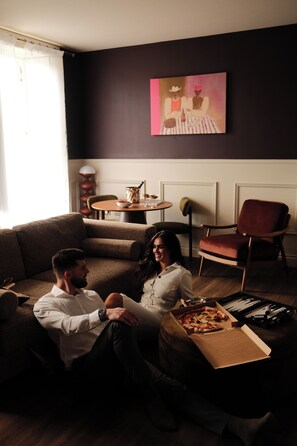 A living room with a sofa, a coffee table, and a pizza box.