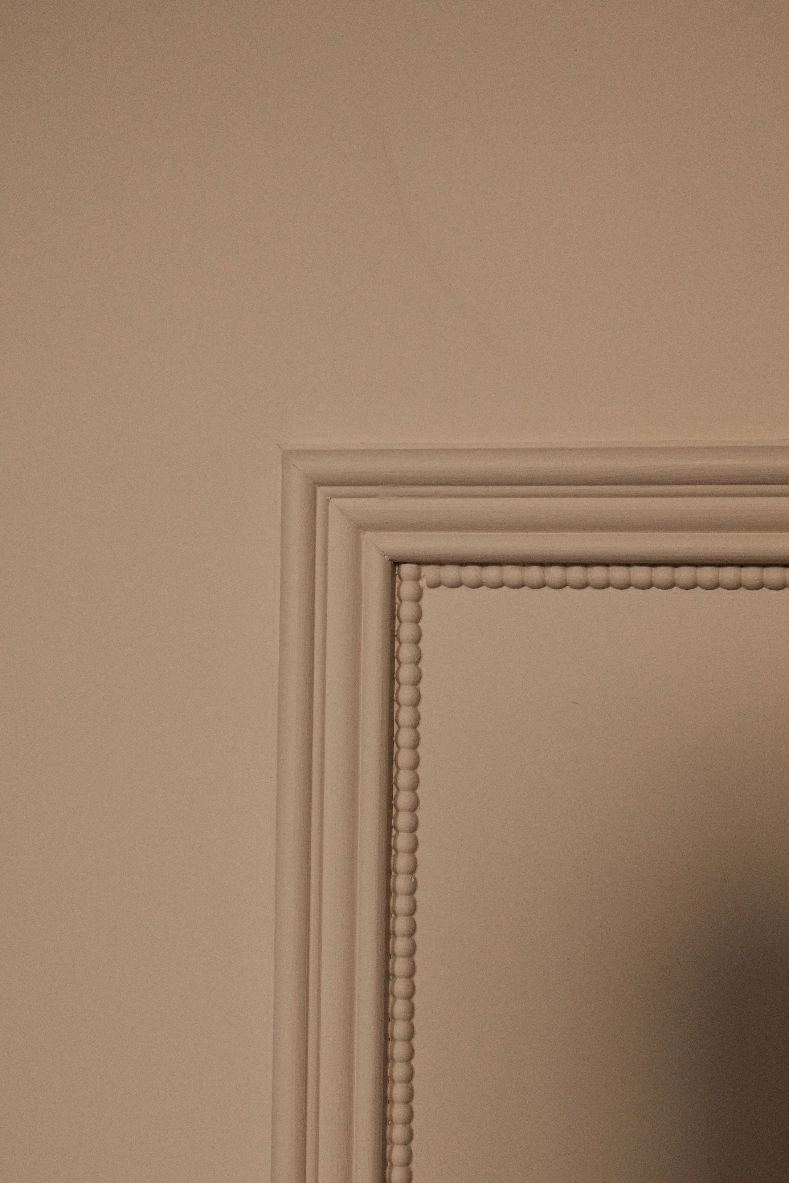 A wall with a decorative molding and a recessed panel.