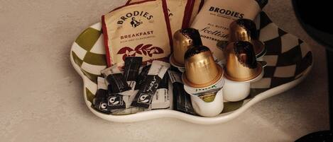 A kitchen counter with a plate of chocolate bars and a coffee maker.
