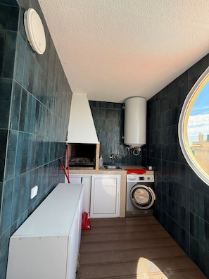 A compact kitchen with a washing machine, a sink, and a window. - Reformed Vintage Top Floor Stunning Views by Bento Box (Quarteira)