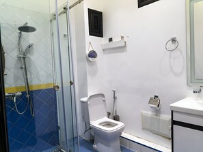 Ein Badezimmer mit Duschkabine, Toilette und Waschbecken.