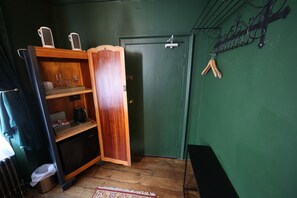 A room with a wooden cabinet, a green door, and a metal rack with hooks. - One bedroom apartment in the heart of Whitby. Close to all local attractions. (Whitby)