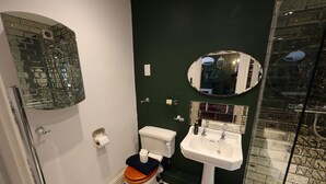 Een badkamer met toilet, wastafel en spiegel.