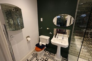 A bathroom with a toilet, sink, and a mirror. - One bedroom apartment in the heart of Whitby. Close to all local attractions. (Whitby)