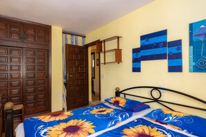 Ein Schlafzimmer mit einem Bett, einem Holzschrank und Bildern an der Wand.