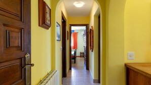A hallway with a wooden door, a radiator, and a light switch on the wall. - Casa Nuestro Sueño for 4 People (Calpe / Calp)