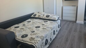 A bedroom with a bed, a wardrobe, a television, and a desk. - Rural County Sligo Studio, Sleeps 2 With Parking (Ballintogher)