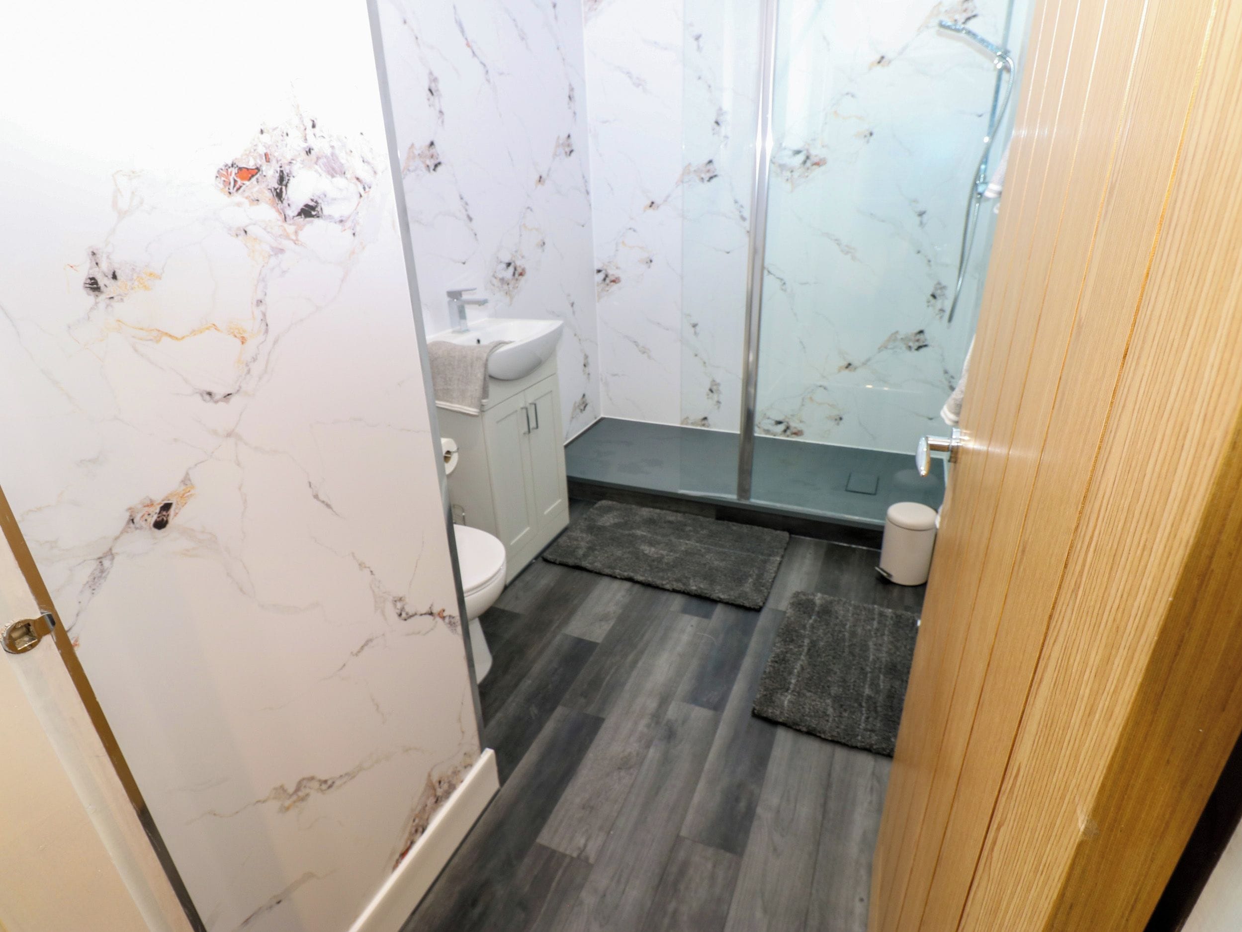 A bathroom with a toilet, sink, and shower area.