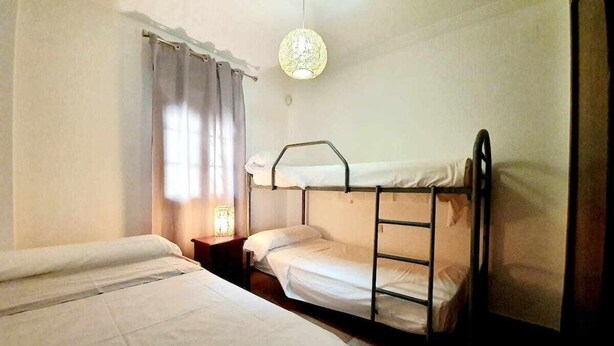 A room with bunk beds, a bedside table with a lamp, and a window with curtains. - Los Pelícanos - Facing the sea, pool and garden - Ref.411F (Punta del Moral)