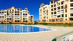 A hotel with a swimming pool, multiple balconies, and a sign indicating a capacity of 240 people. - Los Pelícanos - Facing the sea, pool and garden - Ref.411F (Punta del Moral)