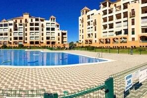 A hotel with a swimming pool, multiple balconies, and a sign indicating a capacity of 240 people. - Los Pelícanos - Facing the sea, pool and garden - Ref.411F (Punta del Moral)
