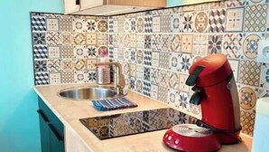Eine Küche mit Arbeitsplatte, Spüle und einem roten Gerät.