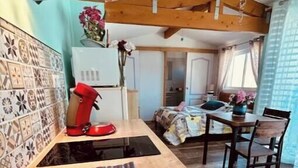 Eine kleine Küche mit Spüle, Herd und einer Essecke mit Tisch und Stühlen.