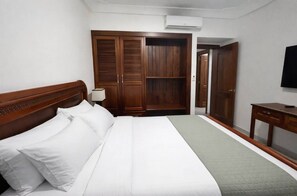 Een hotelkamer met een bed, een kast, een bureau en een televisie.