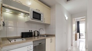 A modern kitchen with a built-in microwave, a coffee maker, a sink, and a dishwasher. - Club Atlantis 150 - One Bed (Costa Adeje)