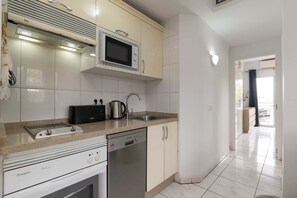 Eine moderne Küche mit Einbau-Mikrowelle, Kaffeemaschine, Spüle und Geschirrspüler.