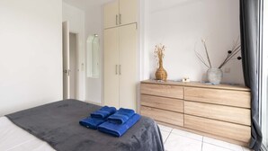 A bedroom with a bed, a wardrobe, a dresser, and a window. - Club Atlantis 150 - One Bed (Costa Adeje)