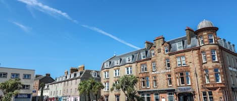A historic building with a prominent corner turret, a sign for the Royal Hotel, and a Harbourview Grill.