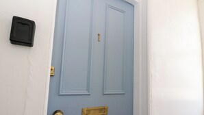 En blå dør med en messingpostkasse, nøglehul og ringeknap.