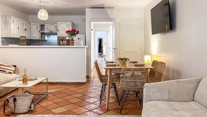 A compact living space with a dining area, kitchenette, and seating area. - Superbe appartement place des lices (Saint-Tropez)