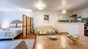 A modern living space with a dining area, kitchenette, and a bed. - Superbe appartement place des lices (Saint-Tropez)